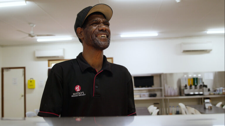 Chris smiling happily in the kitchen at work