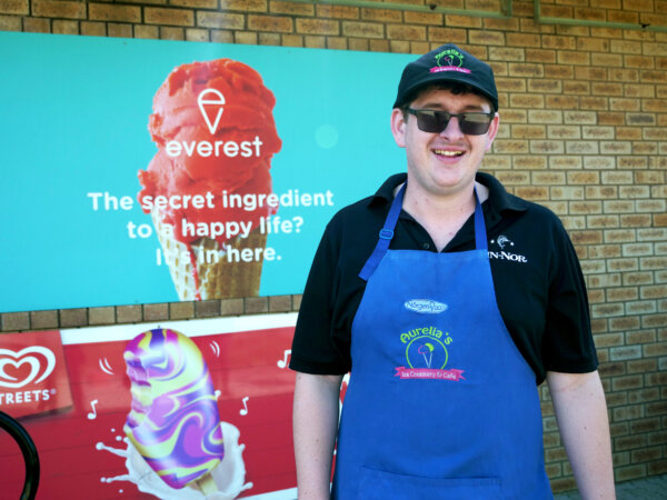 Josh out the front of his workplace, Aurelia's ice creamery & cafe, wearing the work uniform.