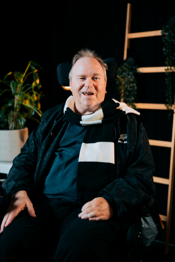 Craig smiling, with an all blacks scarf around his neck.