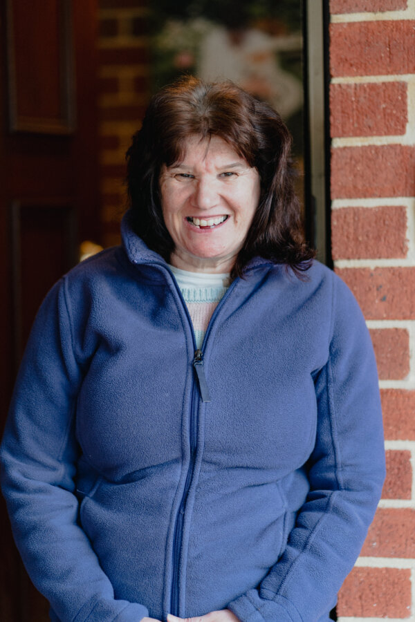 Kathy smiling outside her house. 