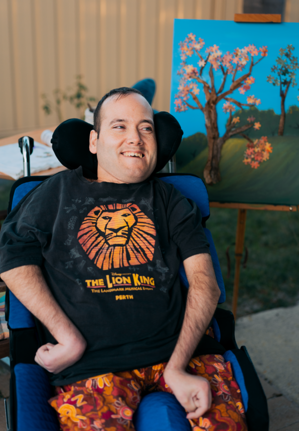 Gareth laughing in his garden with his art. 